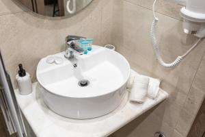 a white sink in a bathroom with a mirror at Breeze Apartments Megara - Linea in Megara