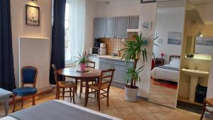 a small apartment with a table and chairs and a kitchen at Studio Neptune in Arromanches-les-Bains