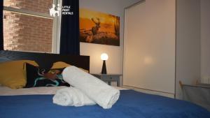 a bed with a pile of white towels on it at Charming 1-Bed with Private Parking & Full Bath in Dunstable