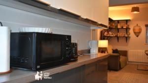 a microwave sitting on a counter in a kitchen at Charming 1-Bed with Private Parking & Full Bath in Dunstable +19 photos