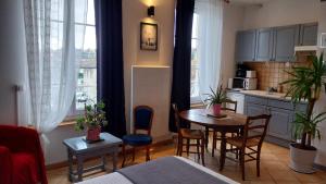 a living room with a kitchen and a table and chairs at Studio Neptune in Arromanches-les-Bains +5 photos