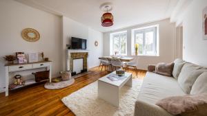 a living room with a couch and a table at Au petit détour Confort in Rolampont