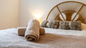 a bed with a rolled up towel on it at Au petit détour Confort in Rolampont