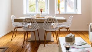 a dining room table with four chairs around it at Au petit détour Confort in Rolampont