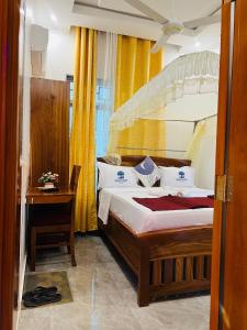 a bedroom with a large bed and a table at Triple E Lodge Kibaha in Kibaha +9 photos