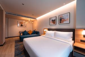 a hotel room with a large bed and a couch at Alt Life Stays - Manyata Tech Park in Bangalore