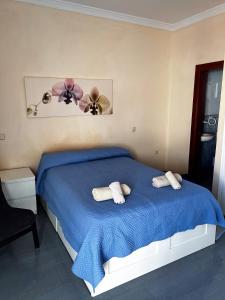 a bedroom with a blue bed with two fans on it at Paradise in El Cotillo in El Cotillo