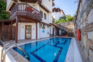 a swimming pool in a house with a balcony at Ankakyaka Apart Hotel in Muğla