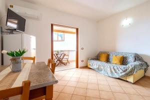 a living room with a couch and a table at Verande Tanca Torre in Isola Rossa