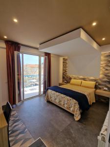 a bedroom with a large bed and a balcony at Mongibello Palace B&B in Mondello