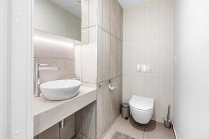 a white bathroom with a sink and a toilet at Metsa terraced house in Haapsalu