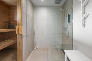 a bathroom with a shower with white tiles at Metsa terraced house in Haapsalu