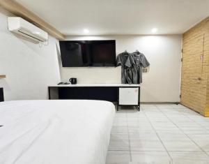 a bedroom with a bed and a desk with a tv at Motel Some in Suwon
