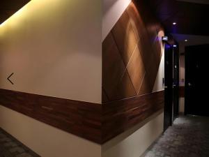 a hallway with a wall with wood paneling and a door at Motel Some in Suwon +2 photos