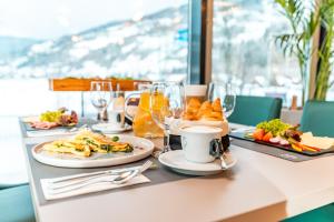 a table topped with plates of food and drinks at ARTMUR Apartment in Sankt Georgen ob Murau