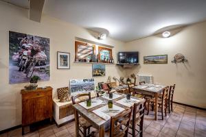 a dining room with tables and chairs and posters on the wall at Locanda il Boschetto in Volterra