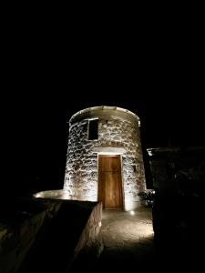 a stone building with a wooden door at night at Petromilos1920 in Zefiría