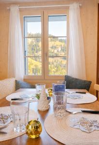 a wooden table with plates and glasses on it at Alpwirtschaft Heirihütte in Rigi Klösterli