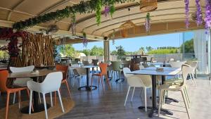 a restaurant with tables and chairs and windows at Valduccina - T3 avec terrasse et piscine, proche de la plage in Lecci