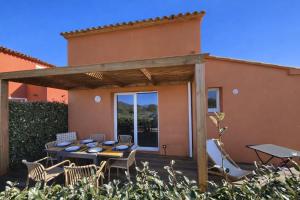 a patio with a table and chairs in front of a house at Valduccina - T3 avec terrasse et piscine, proche de la plage in Lecci