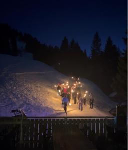 a group of people riding bikes in the snow at night at Alpwirtschaft Heirihütte in Rigi Klösterli