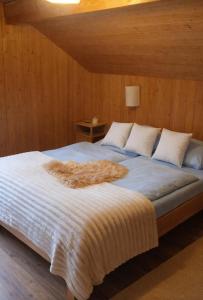 a large bed with a furry blanket on it at Alpwirtschaft Heirihütte in Rigi Klösterli