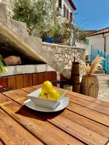 a bowl of lemons sitting on a wooden table at Old Town Charm in Dhërmi