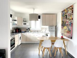 a kitchen with a wooden table and white appliances at Art_Booking . . . by Benoit_B in Duingt