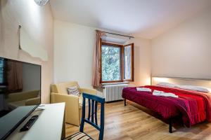 a bedroom with a bed and a desk with a computer at Locanda il Boschetto in Volterra