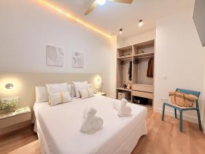 a white bedroom with a large white bed and a chair at Suite 1 Premium, accesible y luminoso by VidaCalma in Valencia