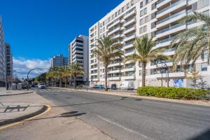 an empty street with palm trees and a large building at Suite 1 Premium, accesible y luminoso by VidaCalma in Valencia
