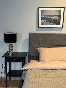 a bedroom with a bed and a night stand with a lamp at A33 central studio aparthotel in Liepāja