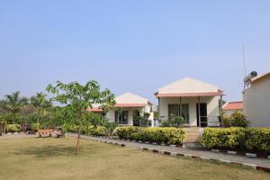 a house with a garden in front of it at Vanray Farm And Resort in Talala