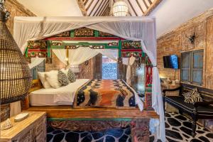 a bedroom with a canopy bed in a room at Kai's Beachfront Villa in Gili Islands