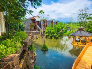 a pond with a gazebo in front of houses at Chevilly Resort & Camp in Bogor