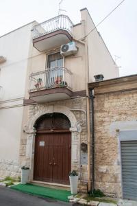 a building with a wooden door and a balcony at Almasol in Cassano delle Murge