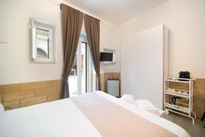 a bedroom with a large white bed and a window at Le Contrade Vico Alba in Monopoli