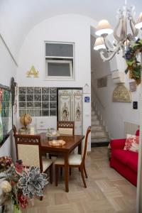 a dining room with a table and chairs and a red couch at Almasol in Cassano delle Murge