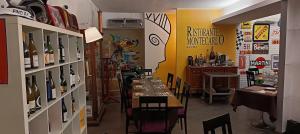 a restaurant with a table with chairs and bottles of wine at Montecarlo B&B in Tortona +16 photos