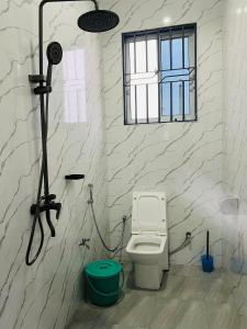 a bathroom with a shower with a toilet in it at Triple E Lodge Kibaha in Kibaha