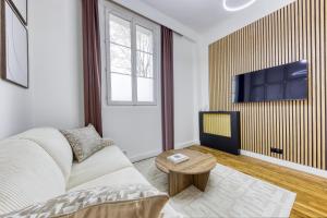 a living room with a couch and a tv at Jacuzzi Romantique, Cosy, Home Cinéma, Paris 10min in Clichy
