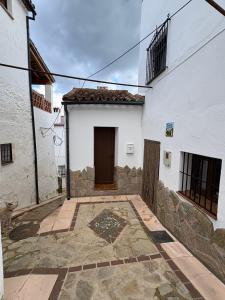 a building with a door in the middle of a courtyard at El callejón in Benarrabá