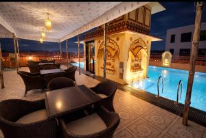 a resort with a swimming pool and tables and chairs at Umaid Residency - A Regal Heritage Home in Jaipur