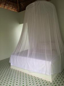 a bed with a mosquito net in a room at Maison de l'Amant in Cai Be