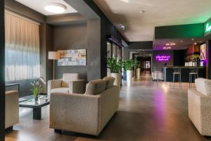 a lobby of a hotel with chairs and a bar at Smart Hotel King, by R Collection Hotels in Varedo