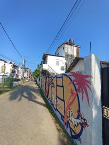 a wall with graffiti on it next to a street at 39 House Weligama in Weligama +3 photos