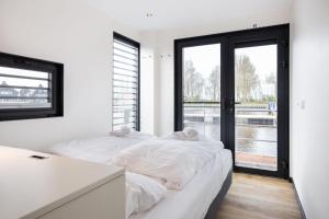 two beds in a room with a window at de Valreep - Paviljoenwei 4 Offinga in Offingawier