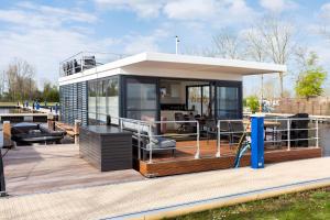 a house on a boat with a deck at de Valreep - Paviljoenwei 4 Offinga in Offingawier