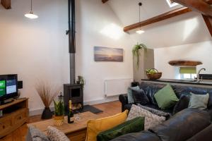 a living room with a couch and a tv at Bryn Lon Bach in Caeʼr-geiliog +9 photos