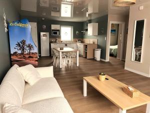 a living room with a couch and a table at Appartement cosy ambiance Malibu dans résidence avec piscine 2 pers 1 chambre in Neuf-Mesnil